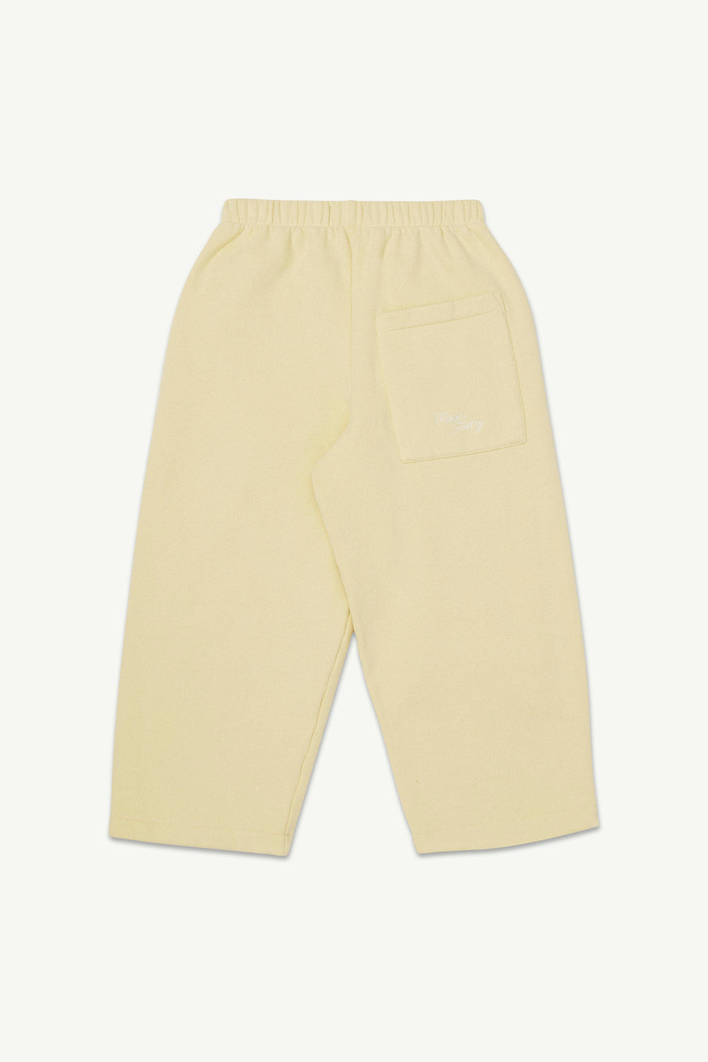 A pair of pale yellow lounge pants shown from the back, featuring an elastic waistband and a single back pocket with a subtle embroidered logo.